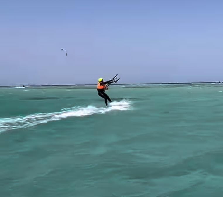 Siggi auf dem Wasser mit Kite über türkisem Meer